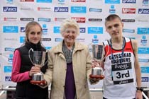 Mrs. Joan Long presents the Stan Long Memorial Trophy to Lydia Turner (Birtley) and Jed Marshall (Gateshead) at the BUPA  Great North Junior Great Run .